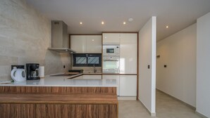 Een moderne keuken met een houten aanrechtblad, inbouwapparatuur en een minimalistisch design.