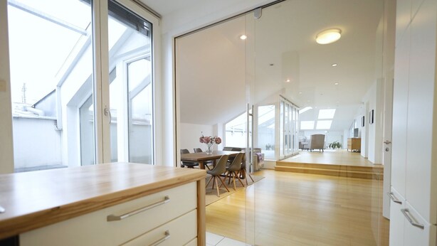 Una cocina moderna con encimera de madera y armarios blancos.