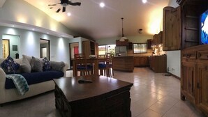 Un salón amplio con sofá, una mesa de centro y un comedor con sillas y una mesa.