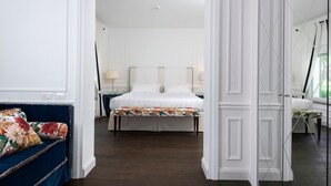 A hotel room with a large bed, a bedside table with a lamp, and a floral-patterned bench. - Casa Tua Spa Resort (Porto Recanati)