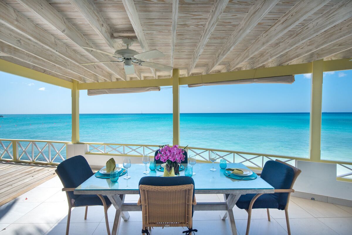A covered outdoor dining area with a view of the ocean.