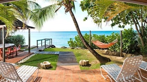 A patio with outdoor furniture, a hammock, and a view of the ocean. - 17th Century Sugar Mill Near Beach - Mullins Mill (Mullins)