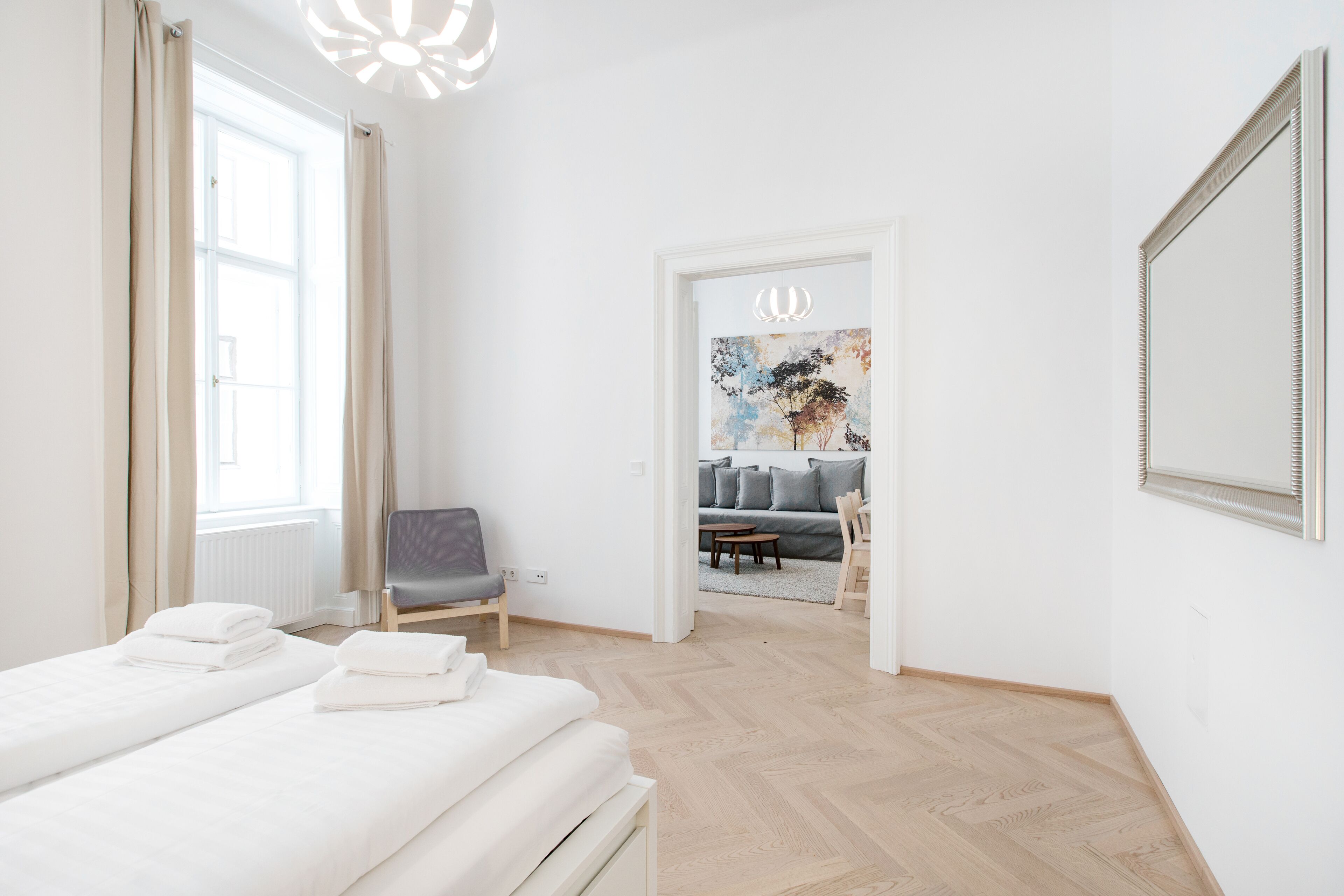 Een hotelkamer met een groot bed, een stoel, een bank en een schilderij aan de muur.