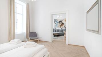 Een hotelkamer met een groot bed, een stoel, een bank en een schilderij aan de muur.