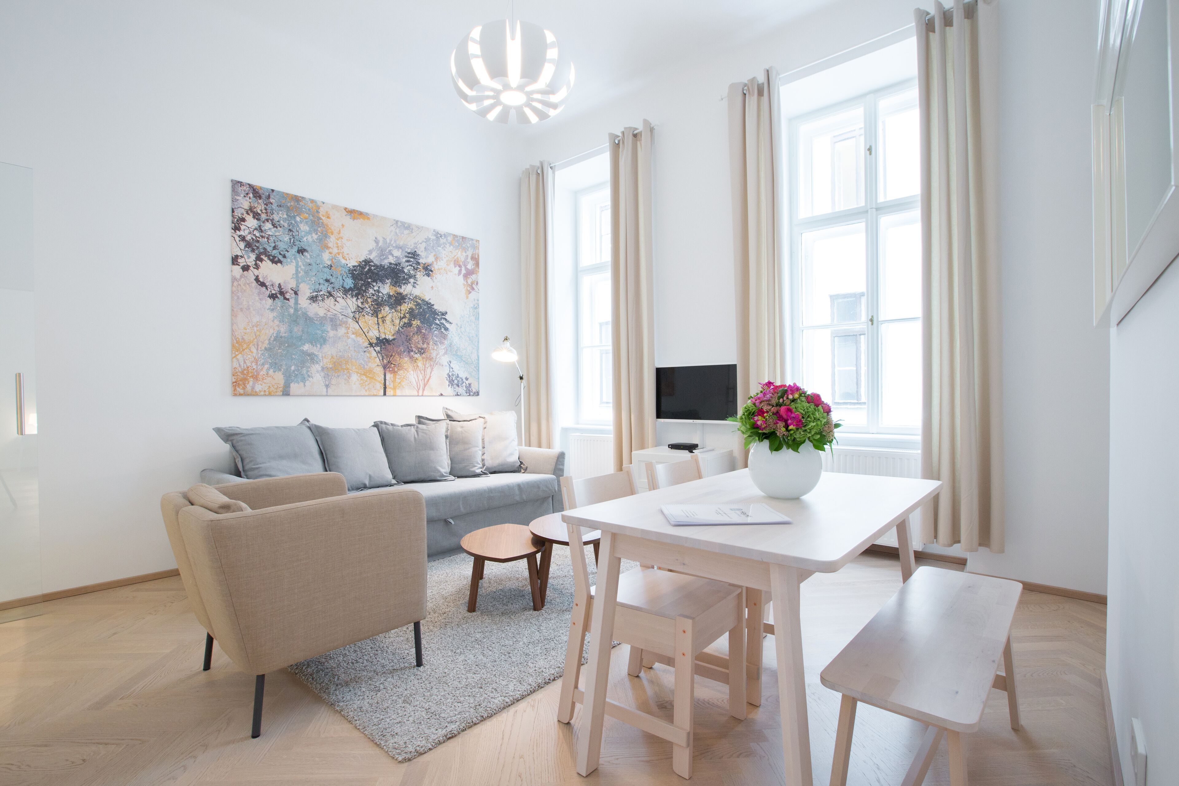 Una sala de estar moderna con sofá, mesa de comedor y televisor.