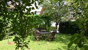 A patio with a table and chairs, surrounded by grass and trees. - Lenardic Bled apartments for 5 person.  (Bled)