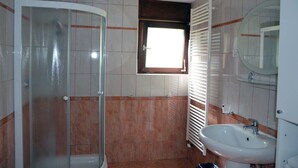 A bathroom with a glass shower enclosure, a sink, a window with blinds, and a radiator. - Lenardic Bled apartments for 5 person.  (Bled)