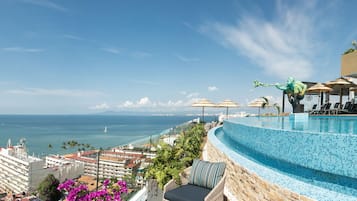 Een buitenzwembad, parasols bij het zwembad en ligstoelen