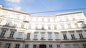 A multi-story building with a symmetrical facade, large windows, and a central entrance. - HeyMi Apartments Stadtpark (Vienna)