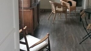 A room with a fireplace, wicker chairs, and a wooden cabinet. - Rental of a Cottage + an Apartment in a Norman character property (Veulettes-sur-Mer)