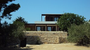 A modern two-story house with a stone wall and a flat roof. - Spectacular tower in front of the sea (L' AMETLLA DE MAR)