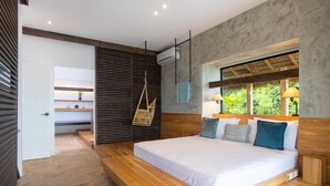 Un dormitorio moderno con una cama grande, cabecera de madera y un banco empotrado.