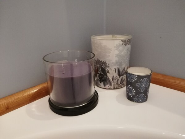 Three candles of different sizes and designs on a white surface. - LikeYourHome, 80 sq m luxury apartment with Jacuzzi, in Trastevere district (Roma)