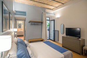 A modern hotel room with a bed, bedside table, lamp, TV, and a view of the outside. - LikeYourHome, 80 sq m luxury apartment with Jacuzzi, in Trastevere district (Roma)