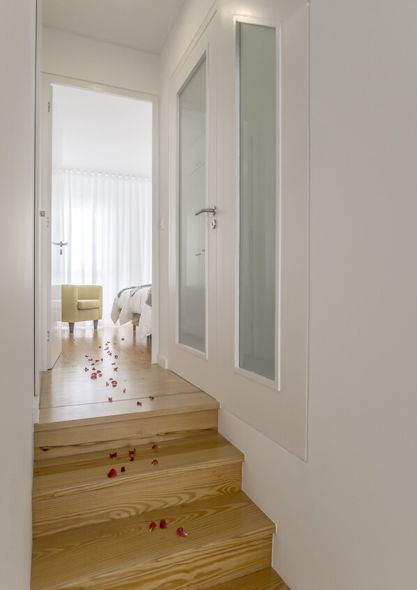 A staircase with wooden steps and white walls.