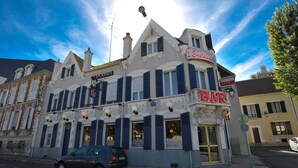 Un edificio con un letrero que dice 'BAR', un letrero que dice 'HOTEL' y un letrero que dice 'L'Esplanade'.