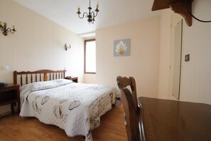 Une chambre à coucher avec un lit, une table de chevet et une chaise en bois.