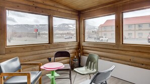 A wooden cabin with large windows, a table, and chairs. - Livingston Inn - Historic (Livingston)