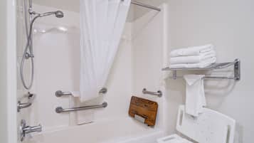 A bathroom with a bathtub, shower, and a white towel rack.