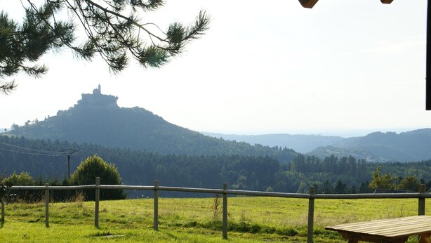 Ein Picknicktisch und der Blick auf einen Hügel mit einem Gebäude auf der Spitze.