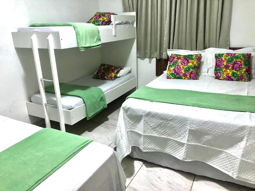 Une chambre avec des lits superposés, un lit simple et une table.
