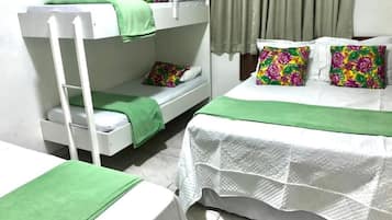 Une chambre avec des lits superposés, un lit simple et une table.
