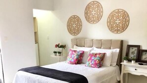Una camera da letto con un letto, comodini, decorazioni a parete e una sedia.