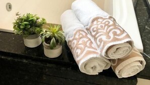 Un bagno con un piano lavabo nero, una vasca da bagno bianca e due piante in vaso.