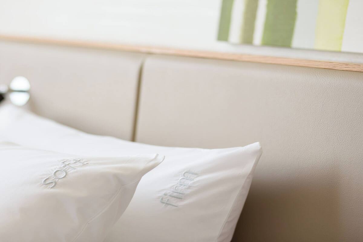 A bed with white pillows and a headboard.