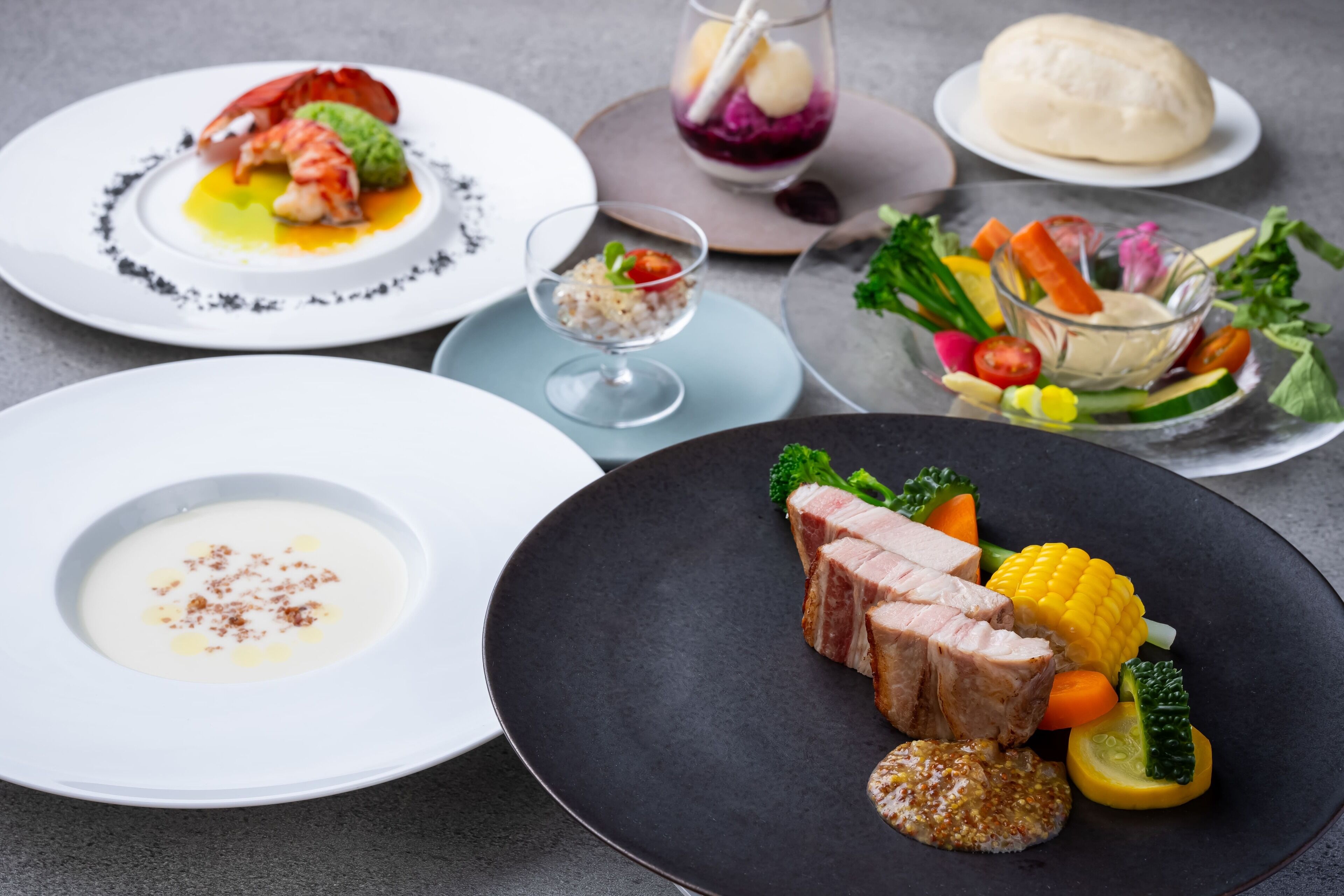 A variety of dishes including seafood, vegetables, and a dessert on different plates.
