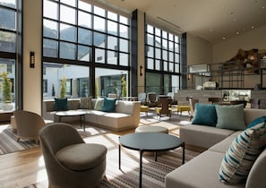 A spacious living area with a large window, a sofa set, a coffee table, and a kitchen area in the background. - Holiday Inn Resort Kuroyon by IHG (Omachi)