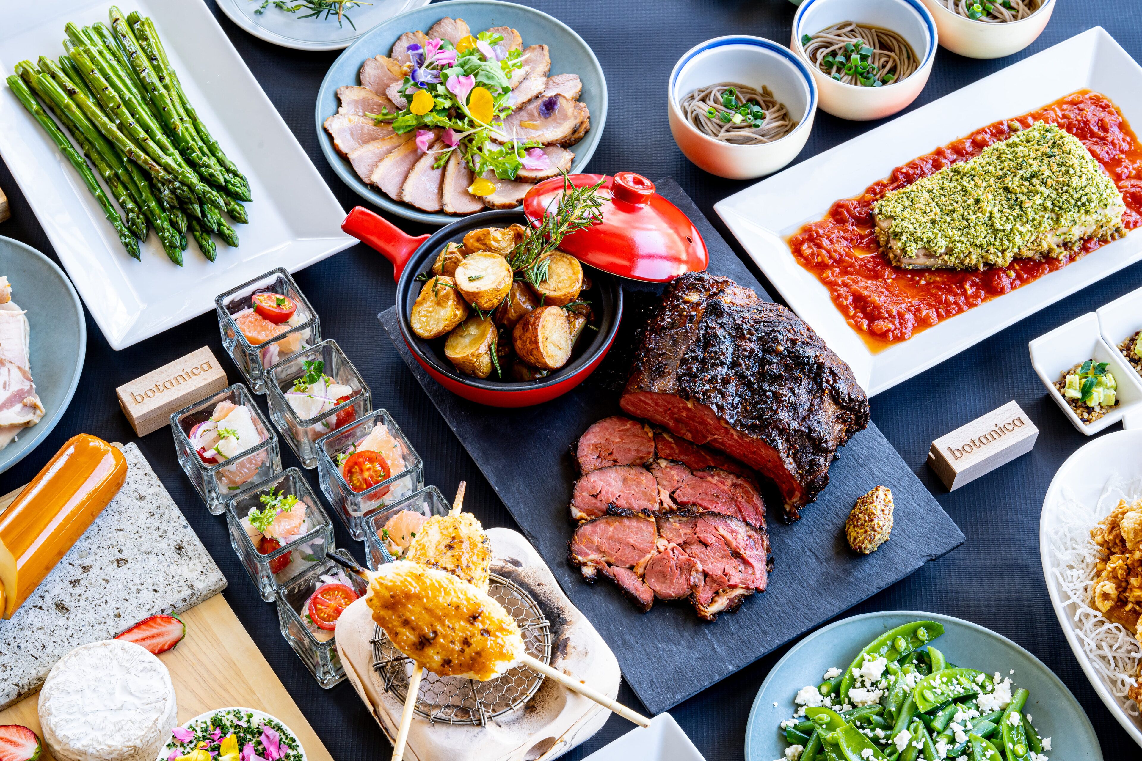 A variety of dishes including asparagus, meat, and vegetables, suggesting a diverse meal selection.