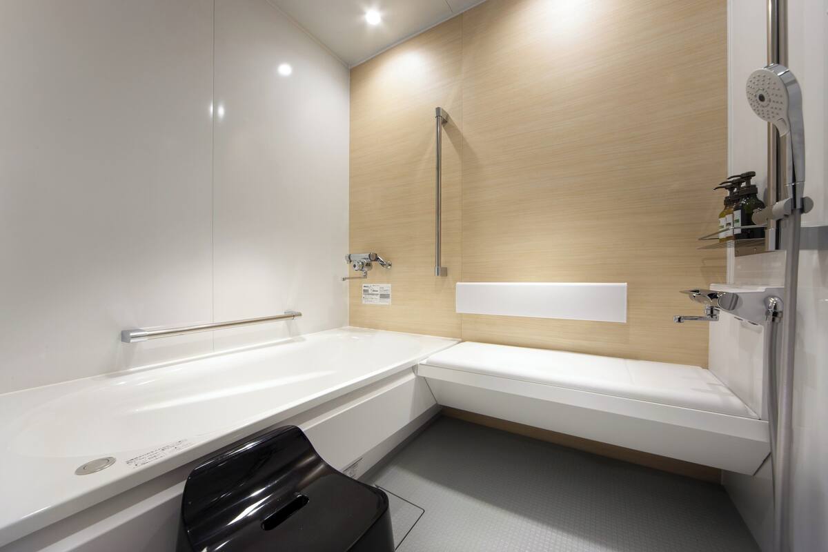 A modern bathroom with a bathtub, a shower, and a toilet.