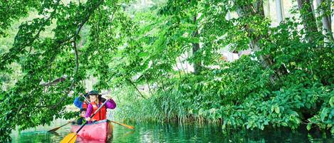 Un grupo de personas en una canoa, navegando por un río rodeado de densa vegetación.