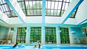 An indoor swimming pool with large windows and a high ceiling. - Holiday Inn Resort Kuroyon by IHG (Omachi)