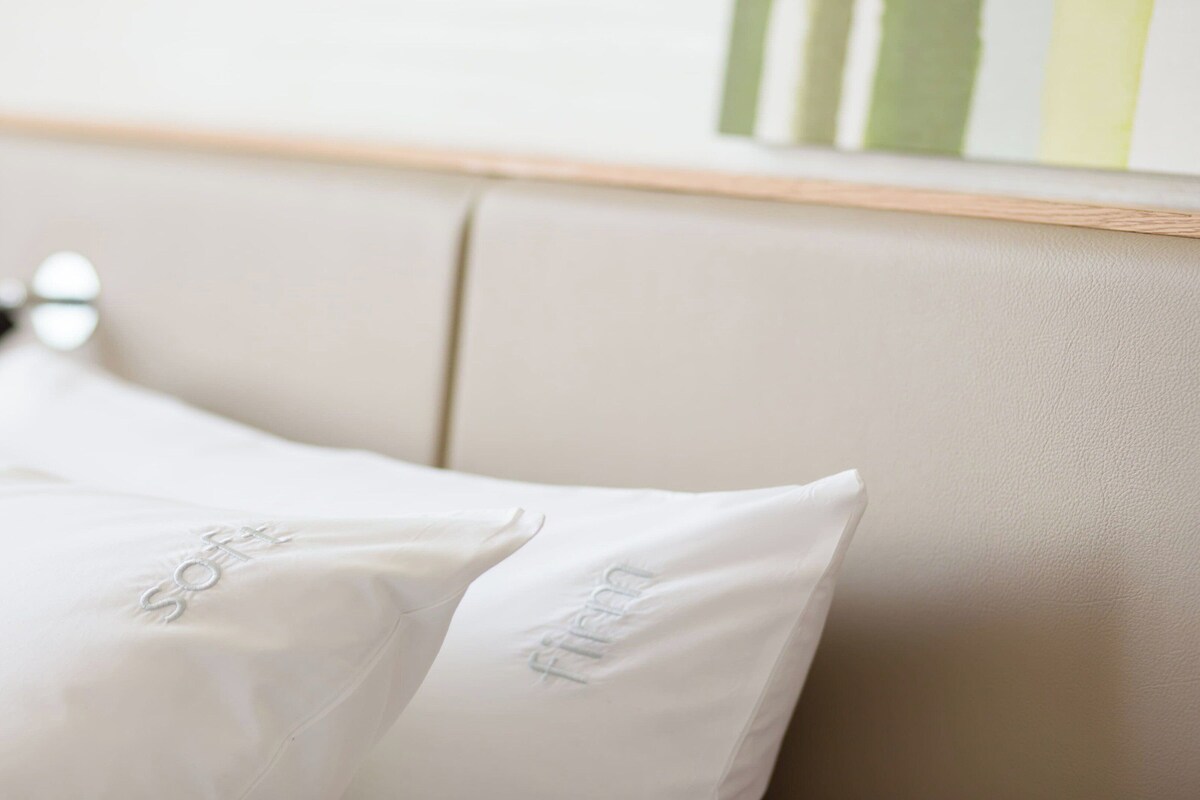 A bed with white pillows and a headboard.