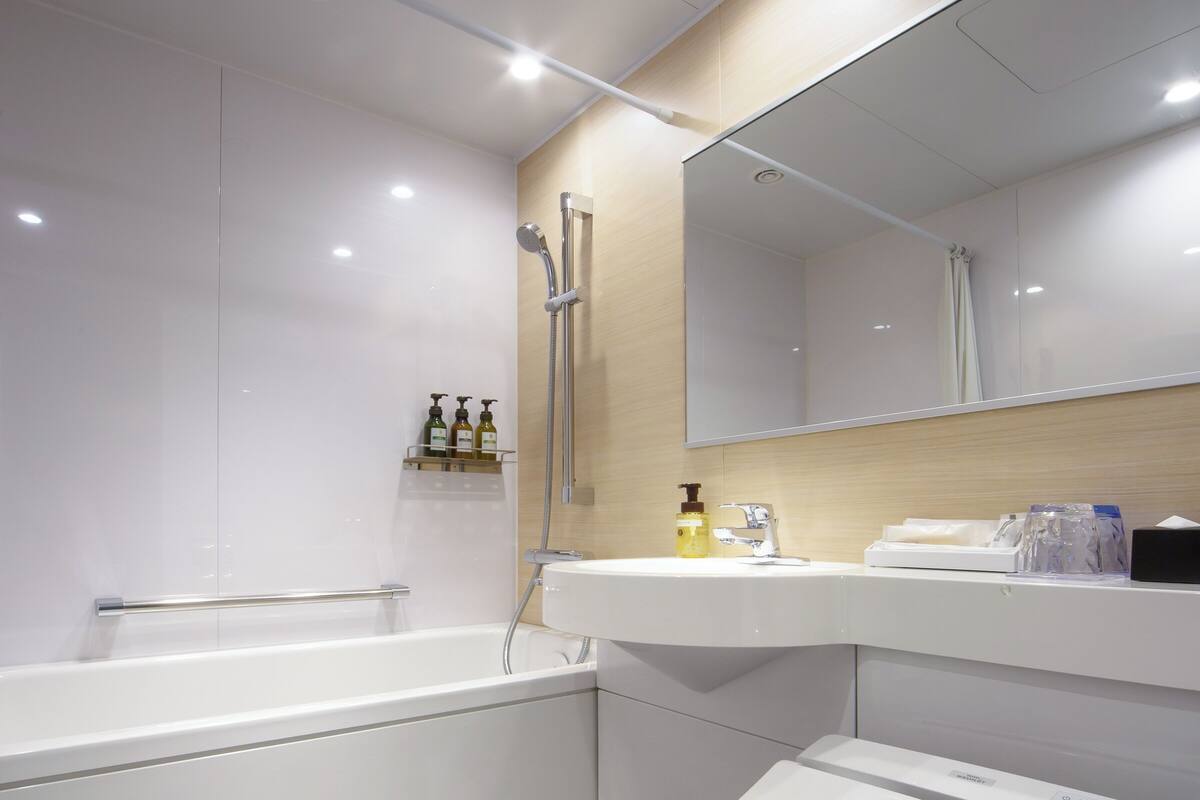 A modern bathroom with a bathtub, a toilet, a sink, and a mirror.