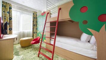 A bunk bed with a ladder, a desk, a chair, and a colorful wall.