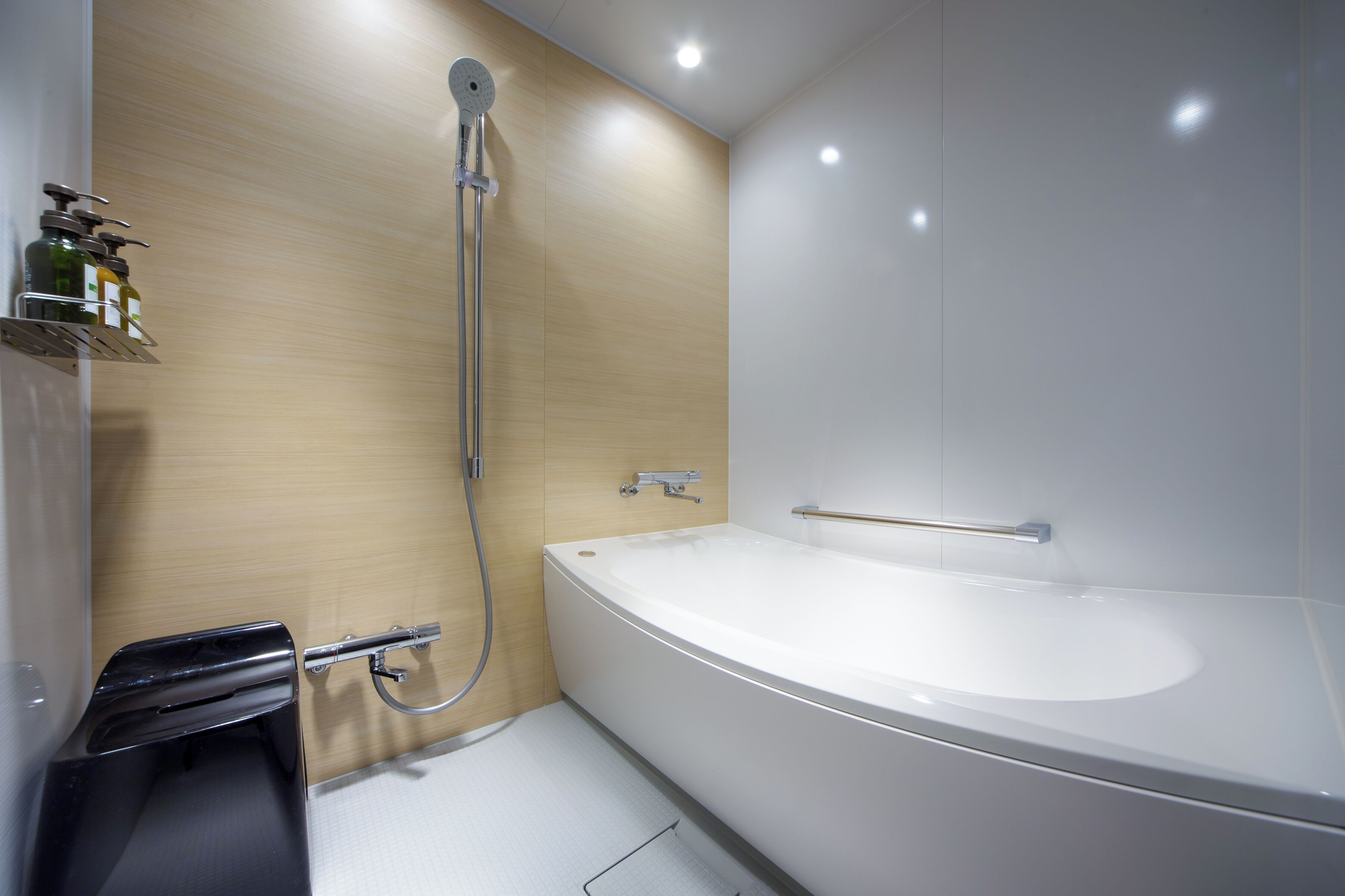 A modern bathroom with a large bathtub, a shower, and a toilet.