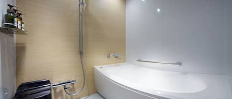 A modern bathroom with a large bathtub, a shower, and a toilet.