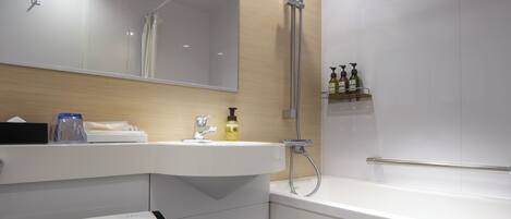 Une salle de bain moderne équipée de toilettes, d’un lavabo, d’un miroir, d’une douche et d’une baignoire.