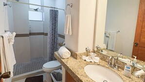 Une salle de bain moderne équipée d’une douche, de toilettes et d’un lavabo.
