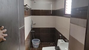 A small, compact bathroom with a shower, toilet, and sink. - Sri Raghavendra Inn (Visakhapatnam)