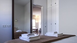 Ein Hotelzimmer mit einem großen Bett, einem Spiegel und Blick auf den Speisesaal.
