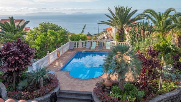 A swimming pool surrounded by tropical plants and a view of the sea. - Quinta da Paz Madeira - Studio View Garden 4 (Caniço)