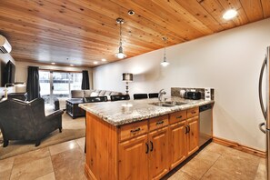 Una cocina moderna con armarios de madera, encimeras de granito y electrodomésticos de acero inoxidable.