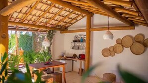 Una cocina acogedora con techo de madera, un comedor con mesa y sillas, y un refrigerador pequeño.