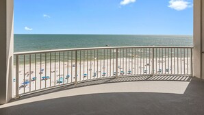 Un balcon avec vue sur une plage et l’océan.