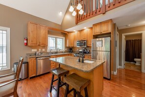 Enjoy cooking in this well-equipped kitchen with a central island, stainless steel appliances, and a dishwasher.