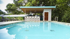A swimming pool with a bar area and lounge chairs. - Modern jungle full apartment in Teva Eco Retreat (Manuel Antonio)
